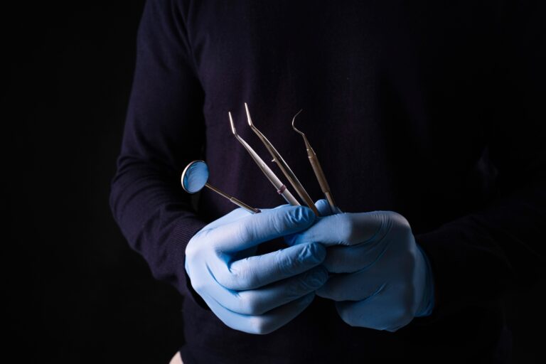 Detail of hand holding dental tools in dental clinic. Dental clinic.